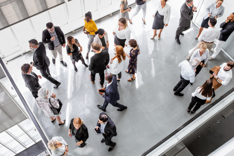 Overhead view of business professionals networking and exchanging referrals during a live event
