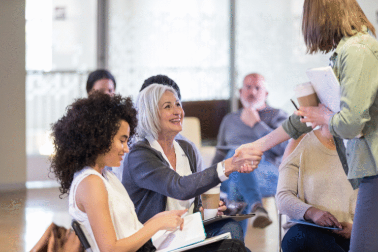 Woman shaking hands during a networking session at a broker seminar