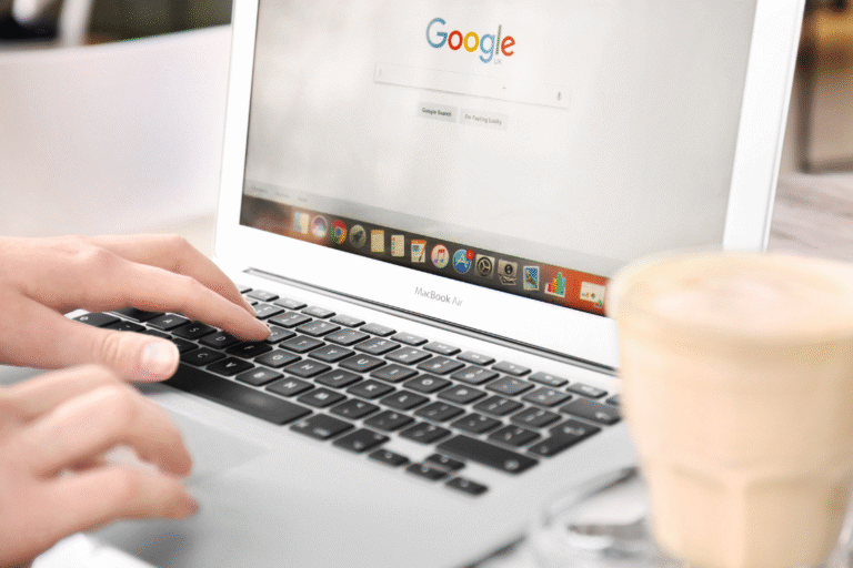 Hands typing on a laptop with Google Search open to find a local business broker