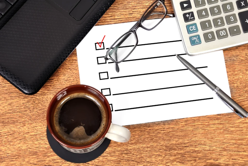 Checklist of clear broker reference questions next to a laptop