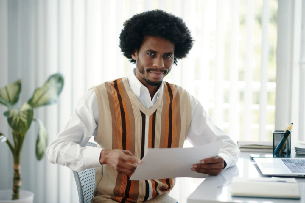 Business professional reviewing a printed engagement letter for selling a business at a desk.