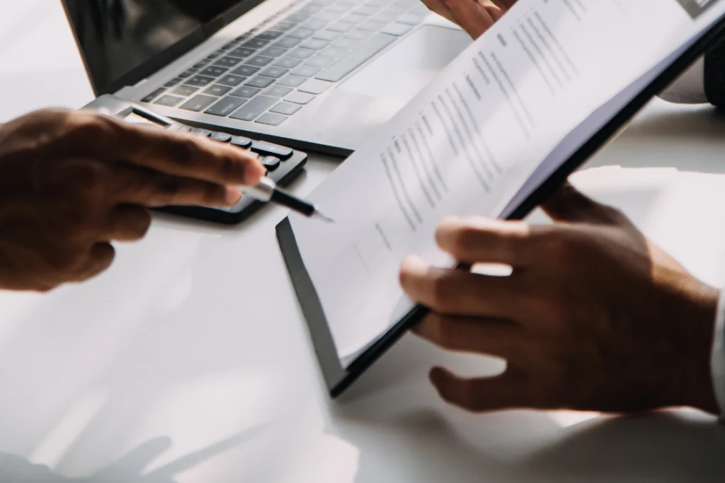 Two people reviewing and signing a document, representing the agreement to broker fees outlined in an engagement letter.