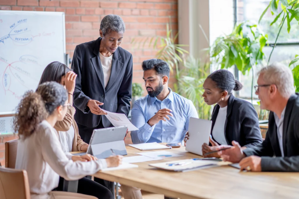 Diverse business team collaborating on SMB broker comparison scorecard in a meeting room.