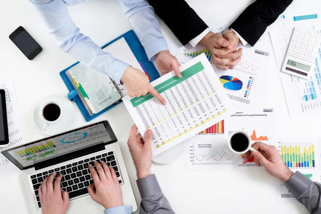 Team analyzing spreadsheets and market data for an SMB broker tiebreaker question evaluation.