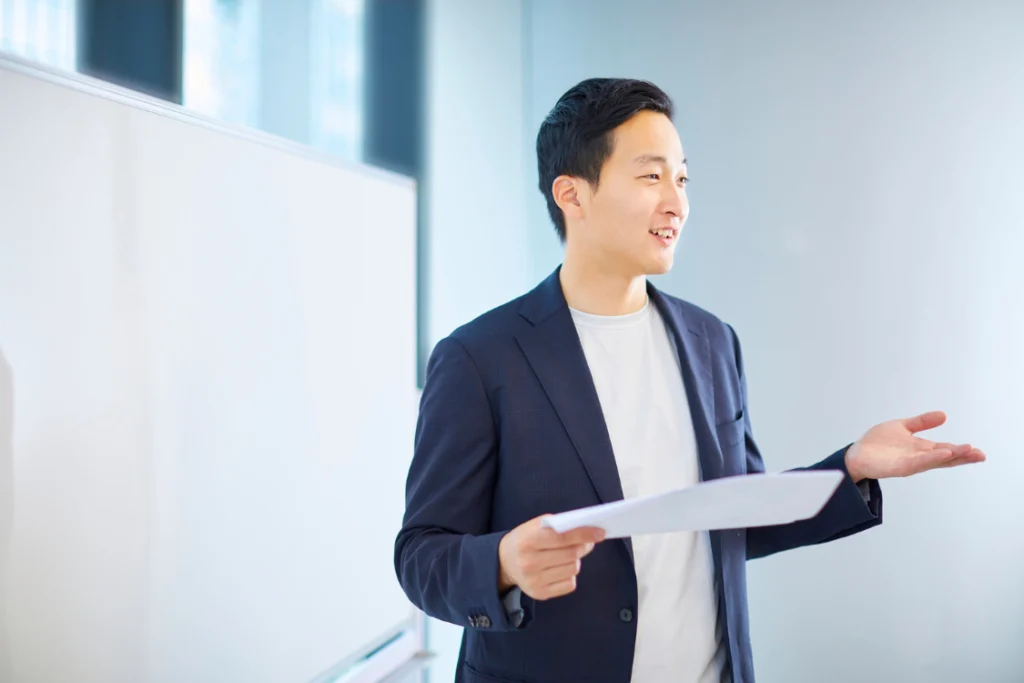 Young business professional speaking confidently during a meeting, showing trustworthy SMB broker traits and strong communication.