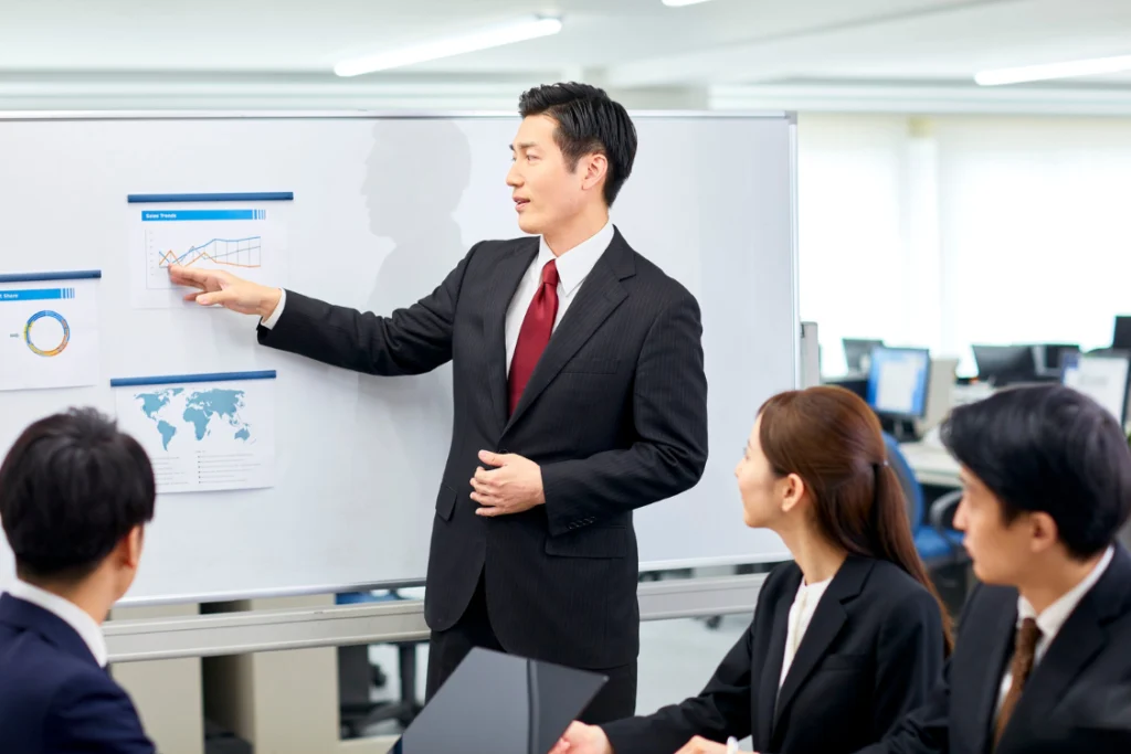 Professional man presenting business data on a whiteboard, illustrating trustworthy SMB broker traits like transparency and clarity.
