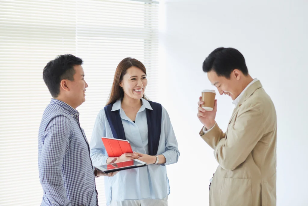 Small business team sharing ideas and laughing together, demonstrating trustworthy SMB broker traits through open communication.