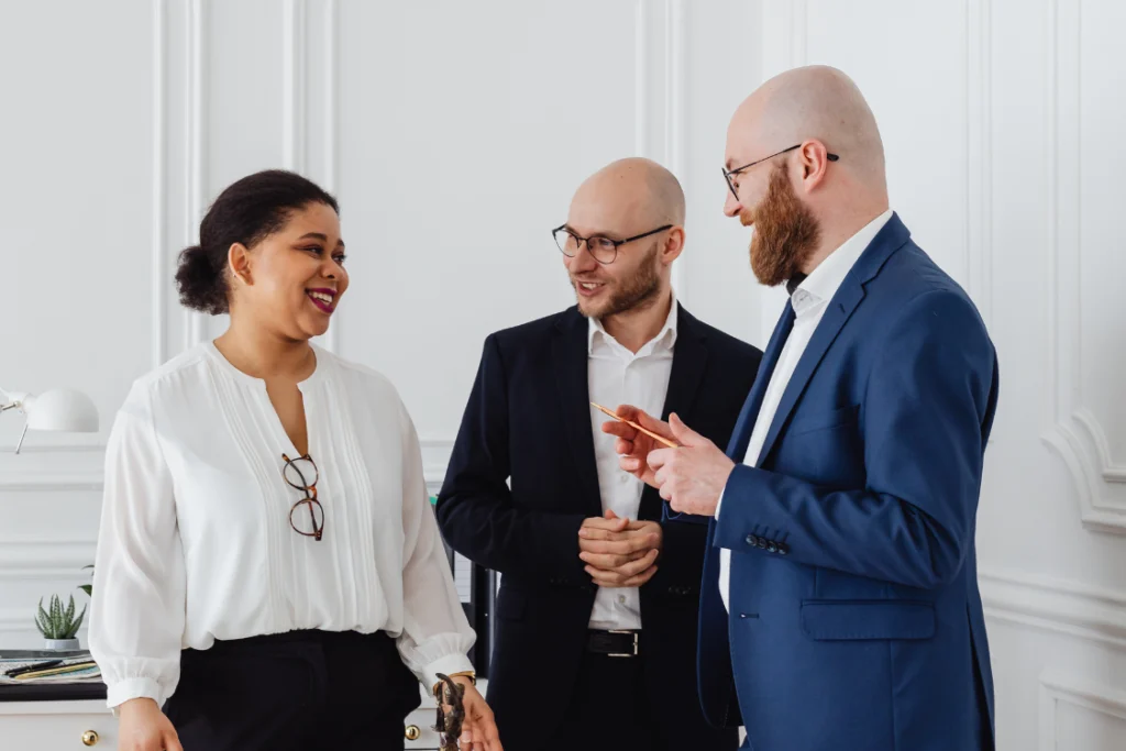 Three business professionals discussing a report, symbolizing the consultation process of business valuation fees with a valuation expert.