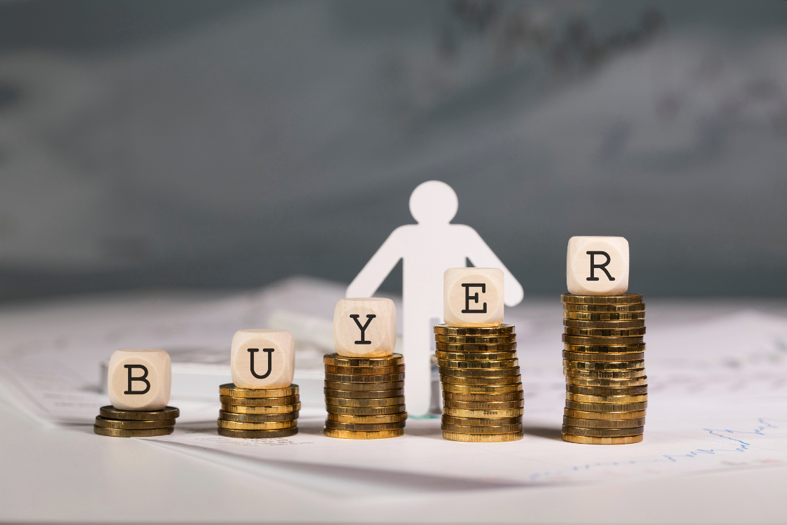 Stacks of coins and dice spelling "BUYER," representing financial thresholds and lead scoring models for qualified leads.