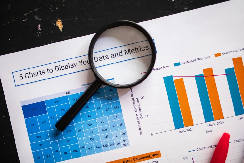 Magnifying glass over charts and data on offers received business sale metrics