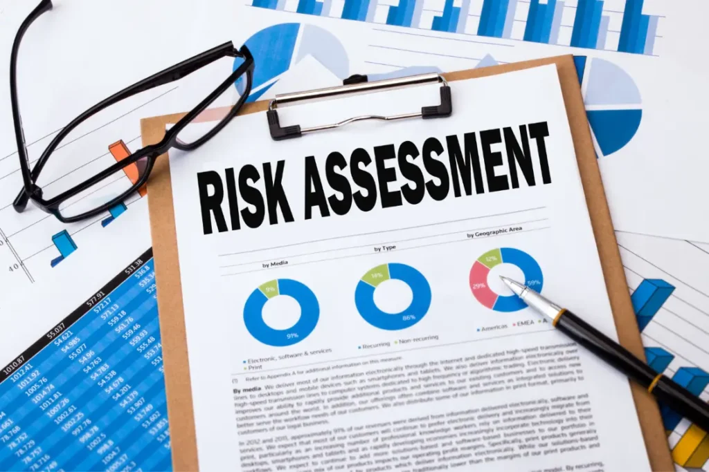 A close-up of a report titled "RISK ASSESSMENT" with financial charts, representing the key step in a private business valuation where risk profile is analyzed.