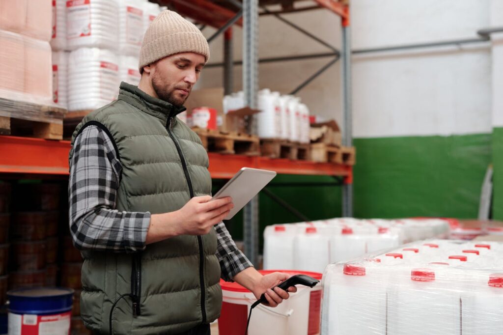 Manager reviewing inventory with a tablet in a warehouse