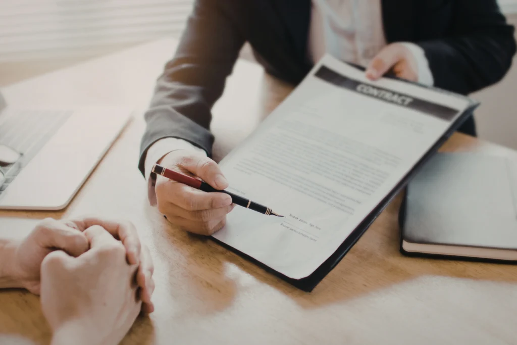 Professional reviewing and pointing at contract on desk