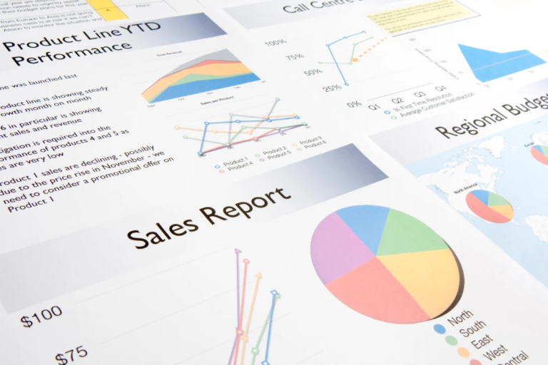 Business valuation reports with product line performance, regional budgets, and sales charts laid out on a desk.