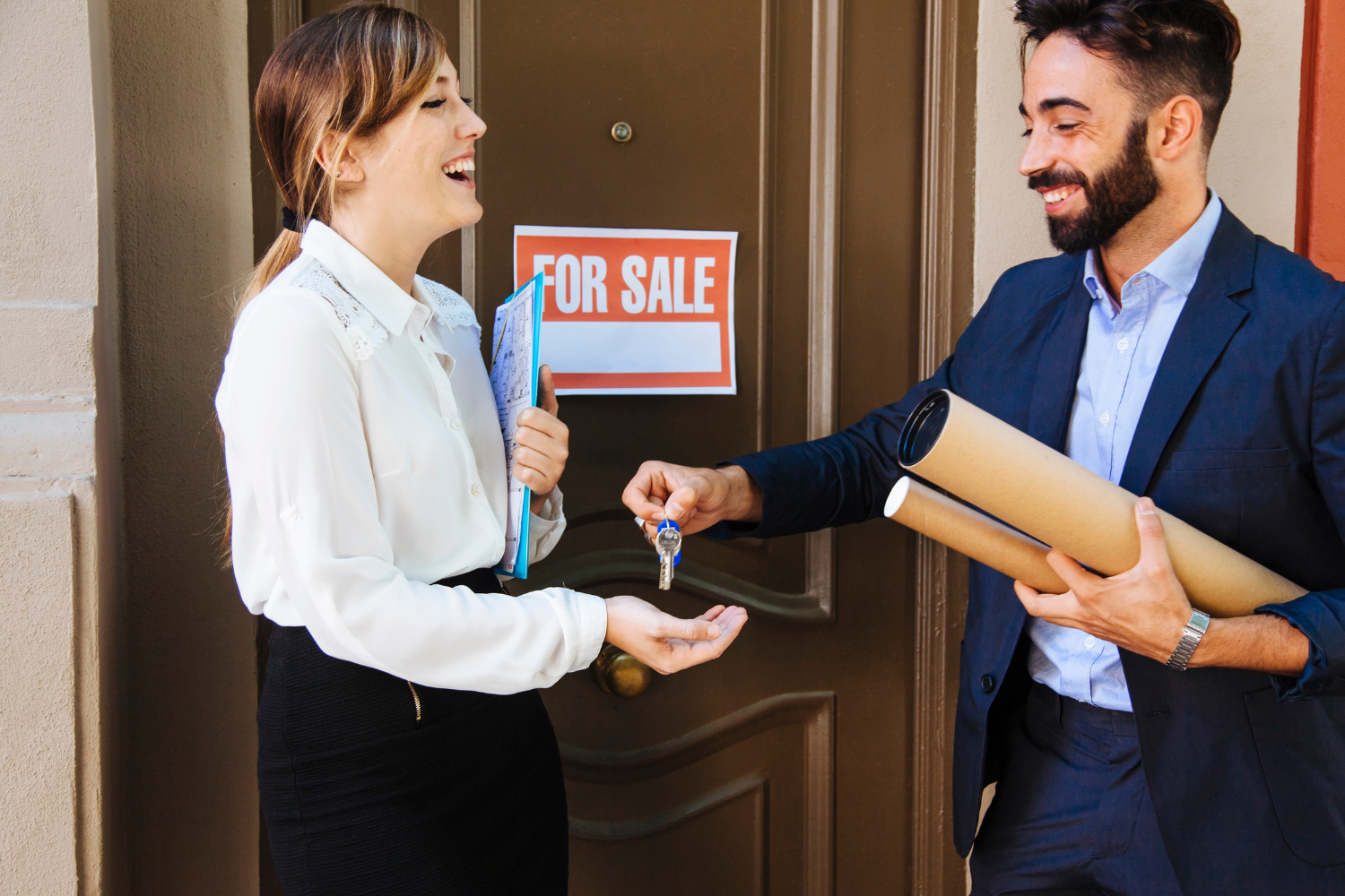 Two people completing a selling a business transaction, with keys and documents exchanged in front of a “For Sale” sign.