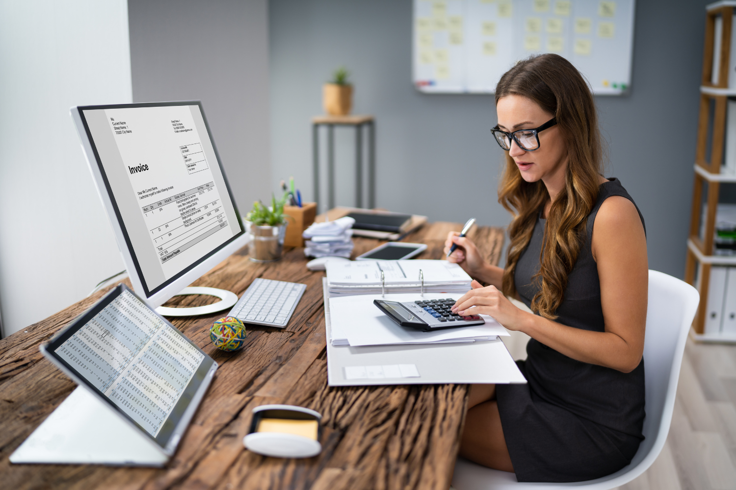 Person working at a desk with invoice and spreadsheet on computer screens, symbolizing tax awareness quick check for selling preparedness.