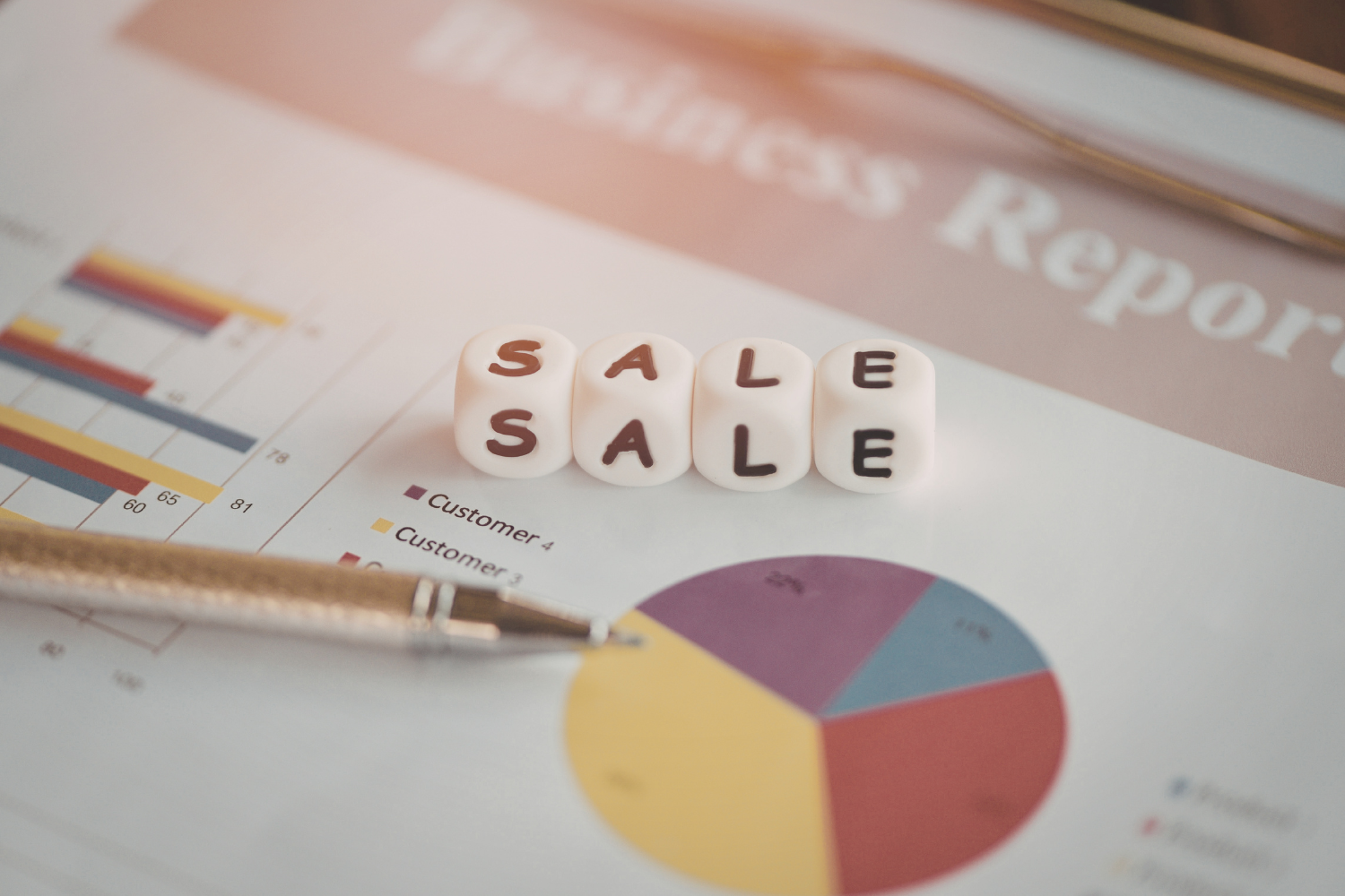 Sale blocks placed on a financial report with charts, representing the risks of rushing a business sale.
